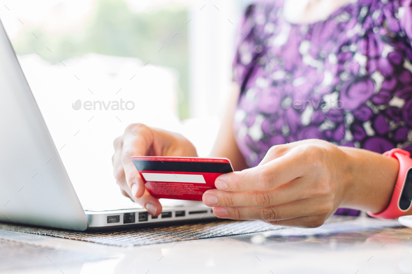 Woman with laptop and credit card in the cafe.