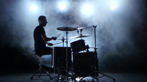 Musician Plays Professionally Good Music on Drums Using Sticks. Smoky Background. Silhouette alt