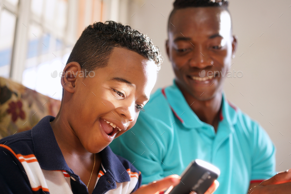 Father Teaching Mobile Telephone Technology To Son At Home - Stock Photo - Images
