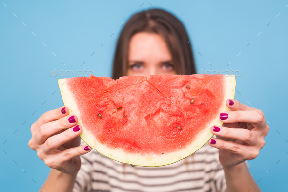 Summer, vacation, diet and vegans concept - Beautiful smiling young woman holding watermelon
