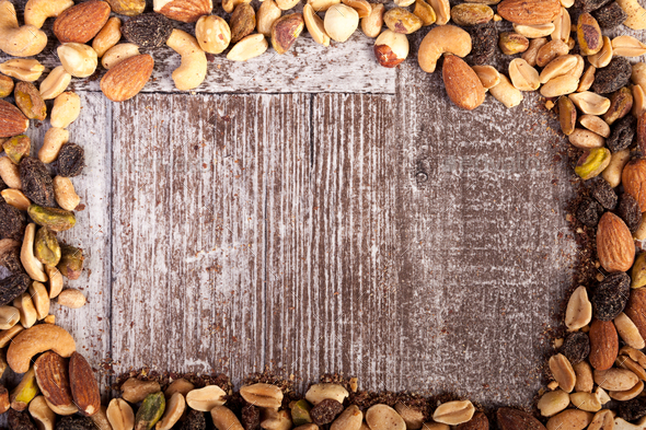 Mix of healthy raw nuts on wooden background with copyspace avai