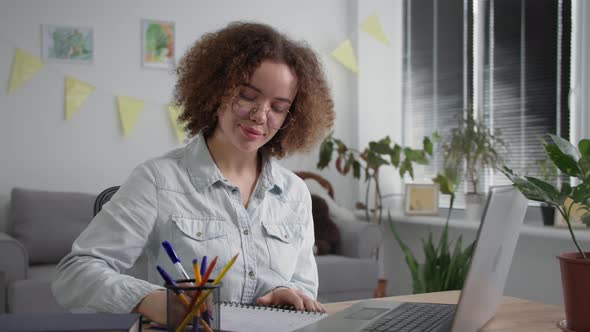 Training Online Young Woman in Glasses Undergoes Distance Learning Talking with Teacher By Video alt