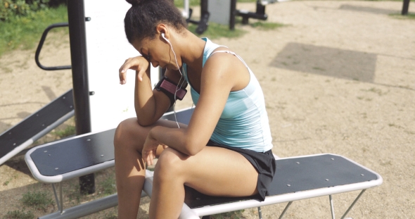 Tired Sportswoman on Bench in Park alt
