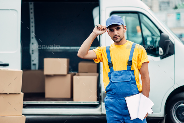 Workman or courier holds carton box in hands - Stock Photo - Images
