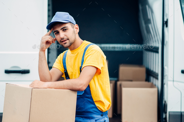 Workman or courier holds carton box in hands - Stock Photo - Images