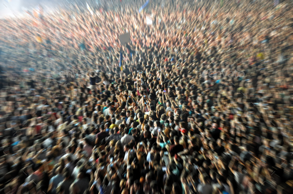 Blurred crowd partying at a music festival. Zoom in effect