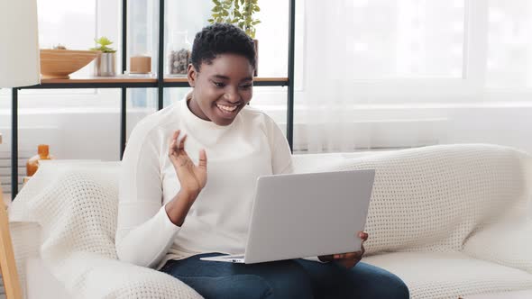 Young Happy African American Woman Waving Hand Hello Greeting Talking at Video Calling Conference alt