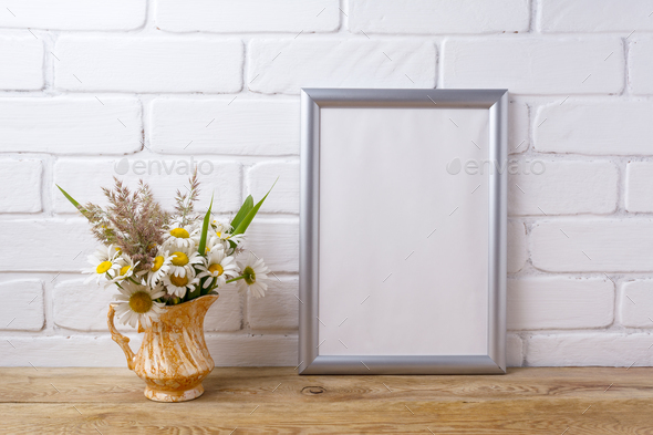 Silver frame mockup with chamomile and grass in golden pitcher - Stock Photo - Images