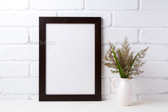 Black brown frame mockup with grass and green leaves in pitcher