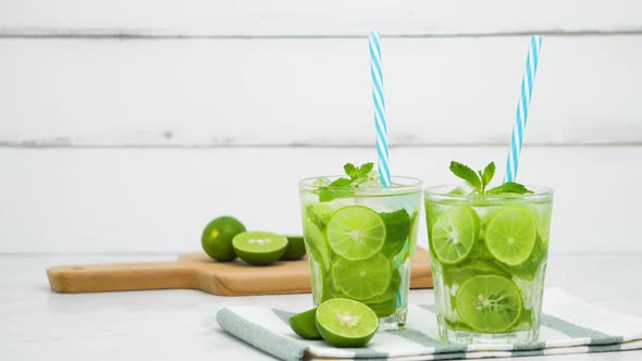 Refreshing Mojito cocktail drinks in the glasses with fresh sliced limes
