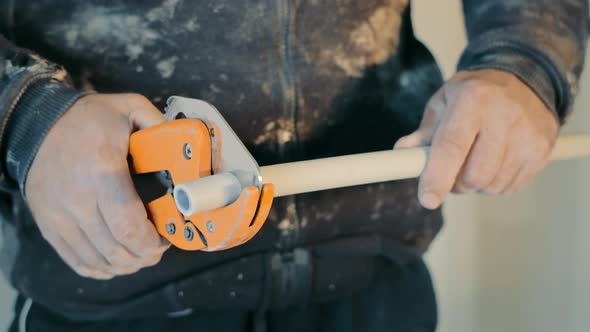 Closeup of a Plumber Cuts a Caesarean Section with a Specialized Cutter and Scissors alt