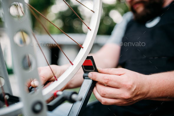 Bicycle mechanic hands repair wheel closeup - Stock Photo - Images