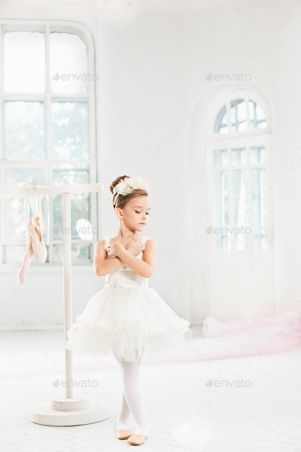 Little ballerina girl in a tutu. Adorable child dancing classical ballet in a white studio. - Stock Photo - Images