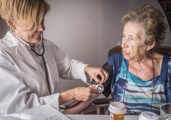 Doctor measures the arterial tension to oldster at home, Andalusia, Spain