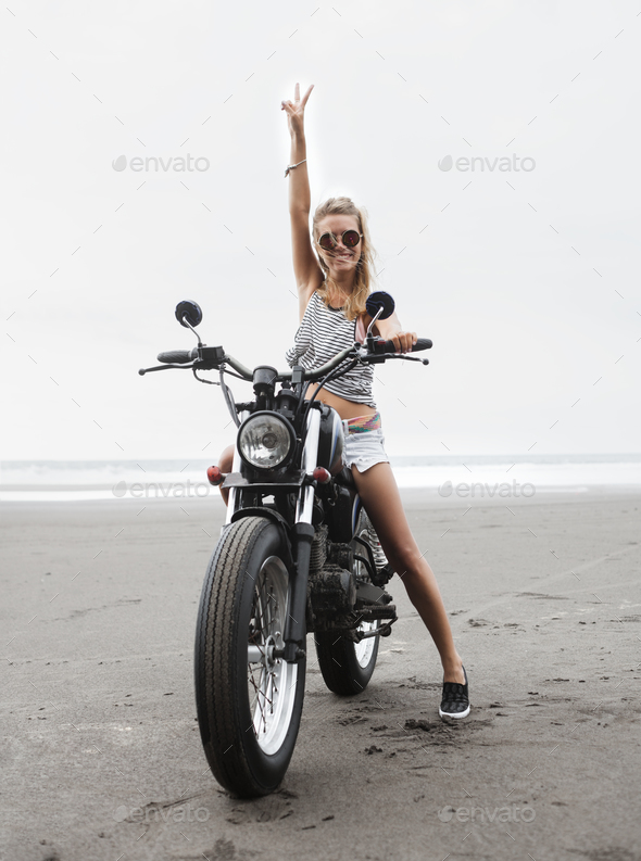 Girl sitting on vintage custom motorcycle