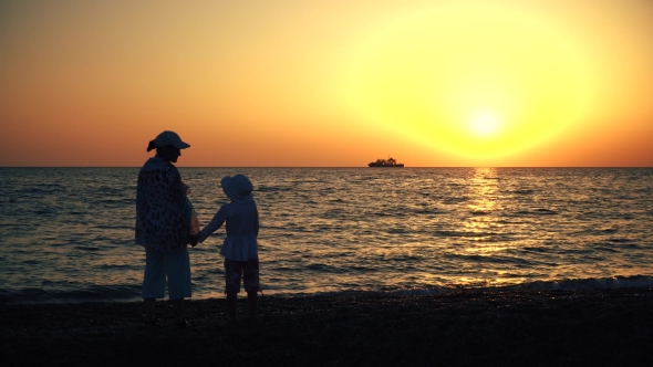Mother and Child Silhouettes and Sunset Over the Sea