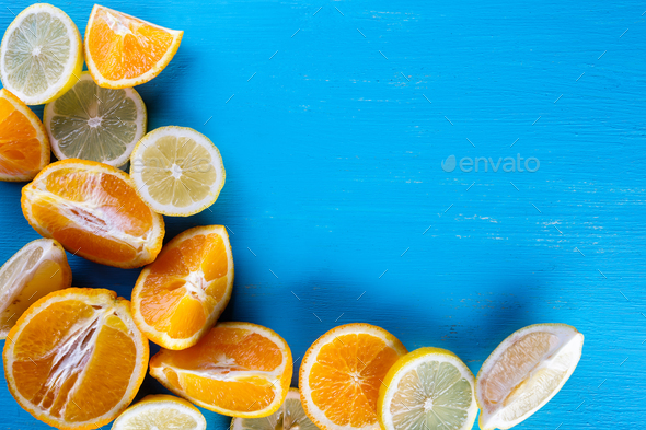 Blue background filled with fresh sliced fruit - Stock Photo - Images