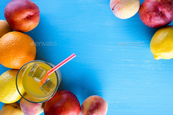 Fresh juicy fruit and cold juice on blue wooden table - Stock Photo - Images