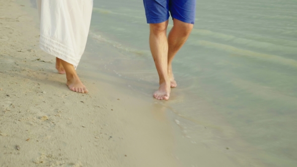 Bare Feet of a Man and a Woman Walk Along the Sand Along the Sea. Holiday Together in the Tropics alt
