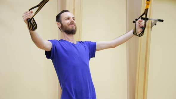 Young Man with Beard Pulling up Doing Physiotherapy Exercises in Fitness Room