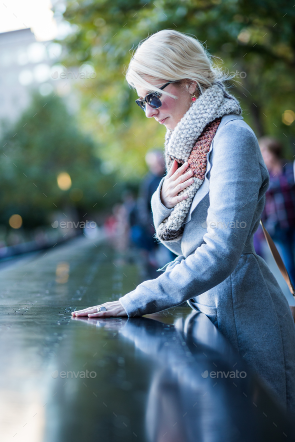 Sad woman looking at the Names of World Trade Center Memorial - Stock Photo - Images