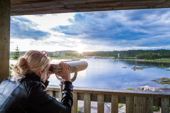 Young Woman Looking at the Amazing Nature Through a Binocular in