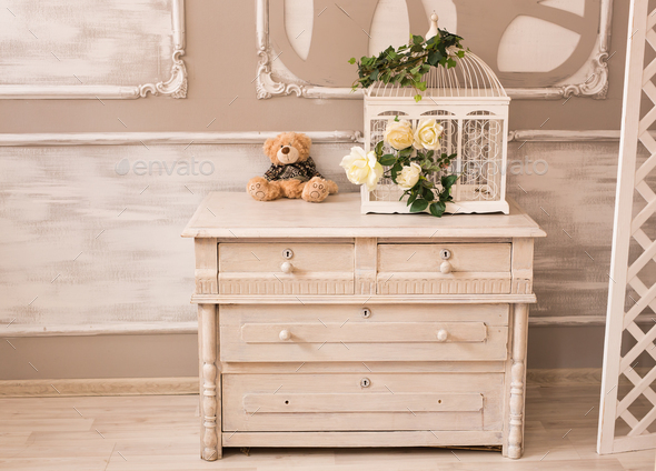 Classic interior of baby room with chest of drawers and teddy bear