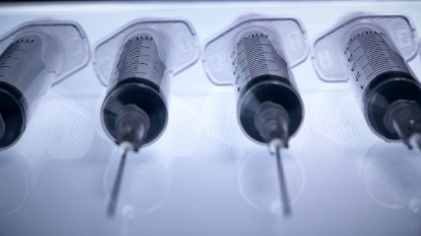 A Lot of Syringes with Liquid on a White Background alt