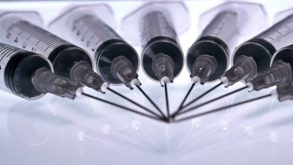 A Lot of Syringes with Liquid on a White Background alt
