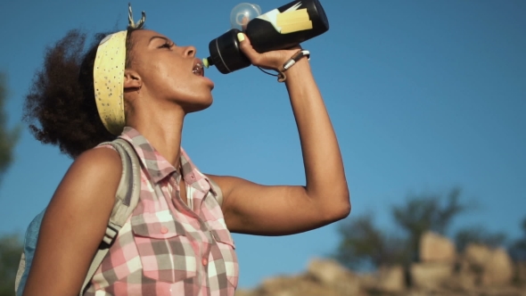 Thirsty Girl Drinking Water While Trekking alt