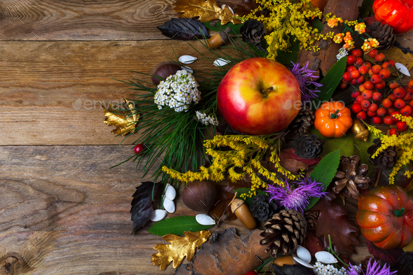 Fall decoration with flowers and apple on wooden table