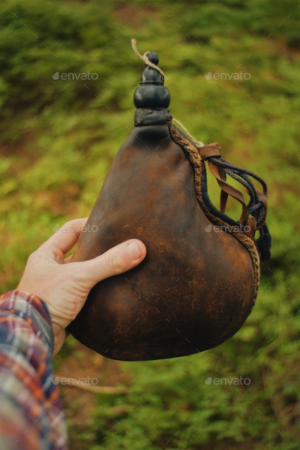 pov, man holding a vintage leather water canteen Stock Photo by  PaulSchlemmer