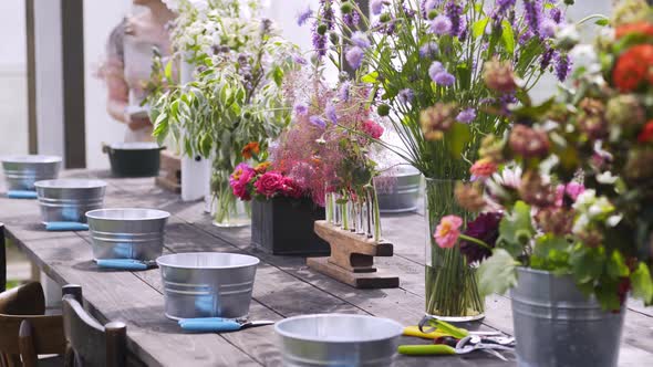 Small Buckets and Pruners Near Vases with Flowers on Table