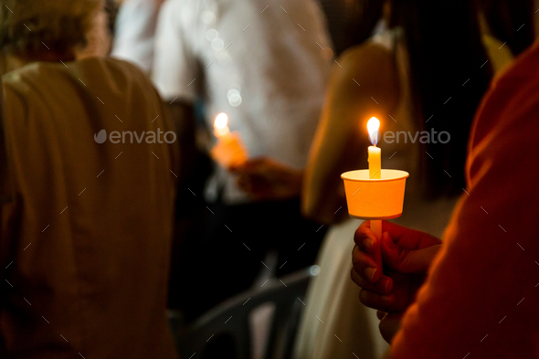 Closeup of people holding candle vigil in dark seeking hope - Stock Photo - Images