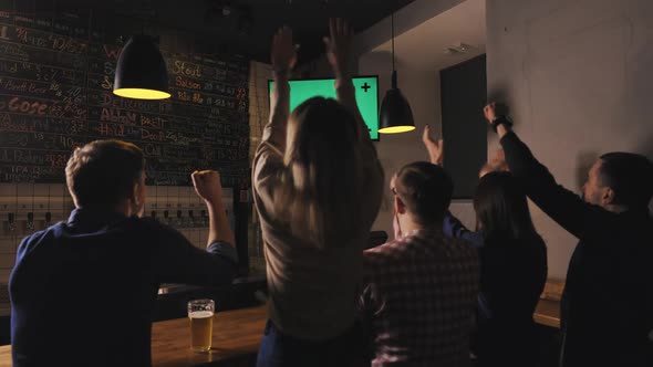Friends in Pub Drink Beer on Bar Counter Watch Sport Game on Tv and Celebrate Goal of the Team