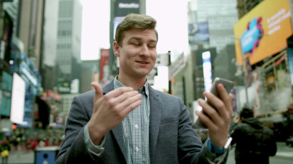 Cheerful Young Man Having a Video Chat on Times Square