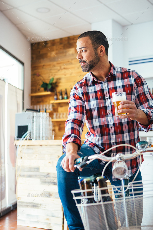 Man with beer on bike indoor
