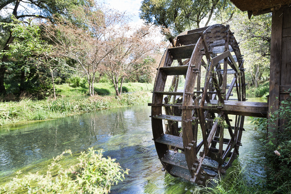Ancient water wheel within serene and scenic river