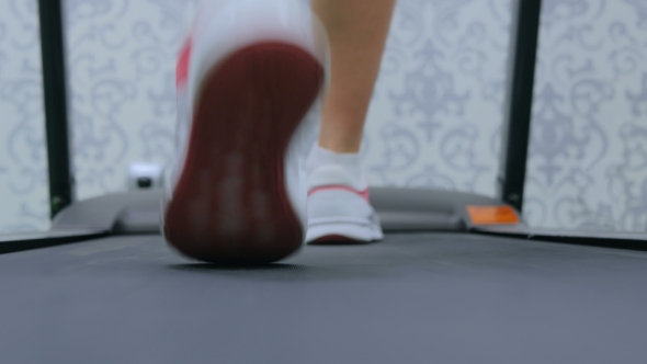 Athletic Young Woman Running on Treadmill at the Gym