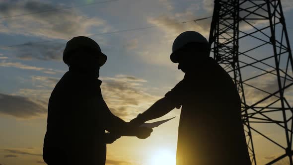 Engineers Shaking Hands at the Construction of High-voltage Power alt