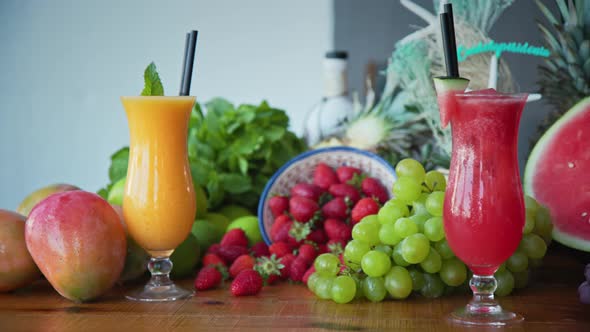 Left to right panning shot of fresh fruits and freshly made fruit juice and smoothies alt