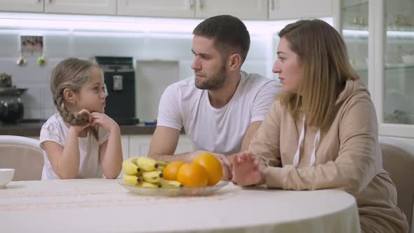 Loving Mother Giving Healthful Orange to Excited Cute Daughter Smelling Fruit and Smiling alt
