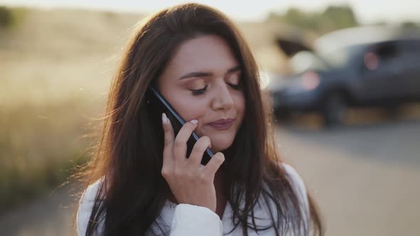 Alone Lady Drinks a Cup of Tea and Emotionally Talks on Phone at Broken Car alt