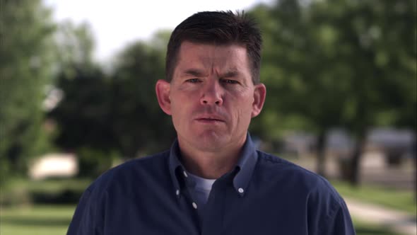 Static shot of an expressionless middle-aged man alt