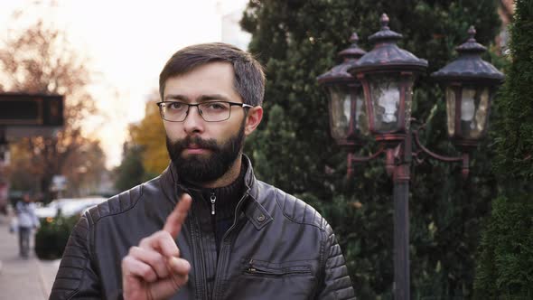 No, Beard Man in Glasses Rejecting Offer By Waving Finger on the Street alt