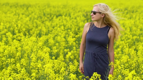 Young Blonde Woman Posing in Beautiful Rapeseed Field