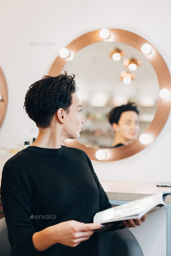 Attractive woman at the mirror in beauty studio - Stock Photo - Images