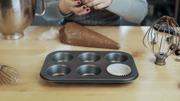 View of Female Hand Putting the Wrappers Paper Cups Into the Baking Tray Woman Cooking Cupcakes alt