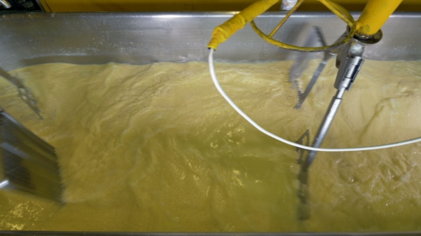 Top View on Swirling Milk Inside a Cheese Vat alt