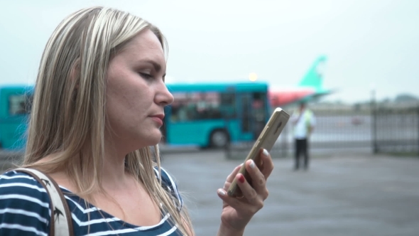 Woman Browsing Smartphone at Airplane. alt